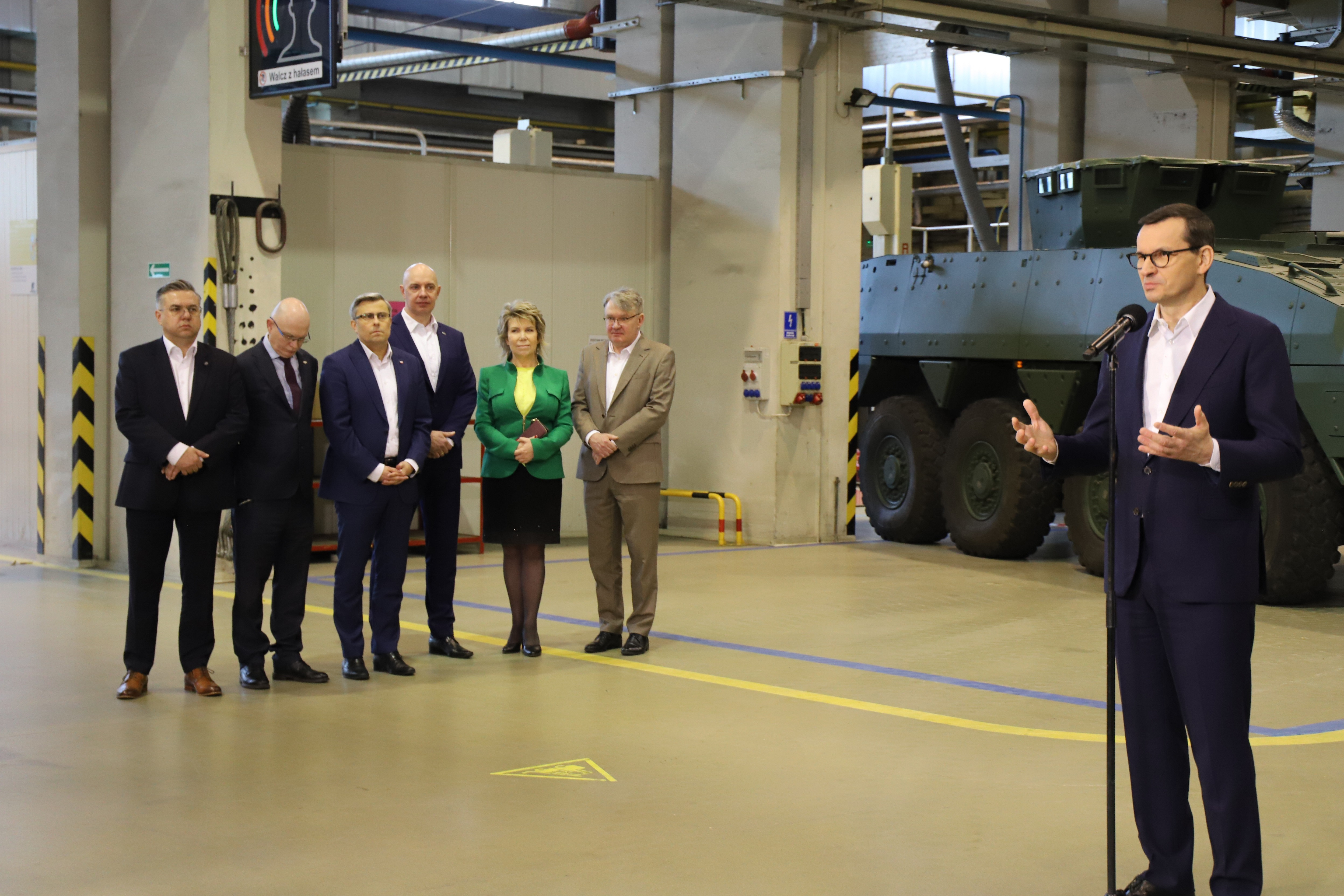 Premier Morawiecki przemawia podczas konferencji. Widoczni są również inni uczestnicy konferencji. 
