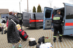Przed siedzibą OSP w Niewieszach - strażacy pomagają wypakować bagaże uchodźców /fot. A. Księżnik/