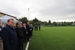 Uczestnicy uroczystości stoją przy murawie nowego boiska/fot. I. Matuszewska