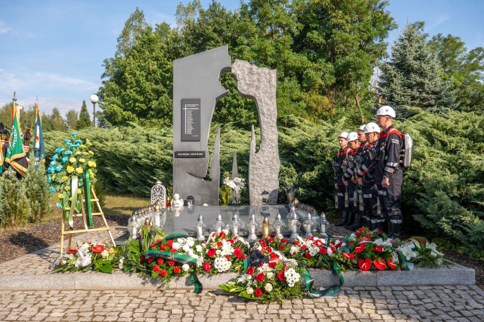 Pomnik Ofiar Katastrofy w Parku Pamięci z kwiatami.