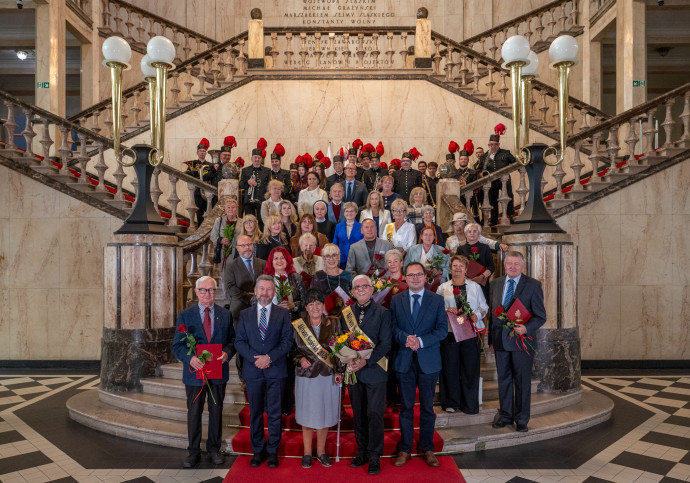 Zdjęcie grupowe uczestników wydarzenia na schodach westybulu.