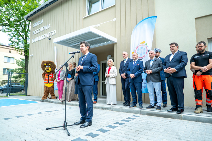 Pokaz ratownictwa medycznego w stacji pogotowia, któremu przyglądają się zaproszeni goście.